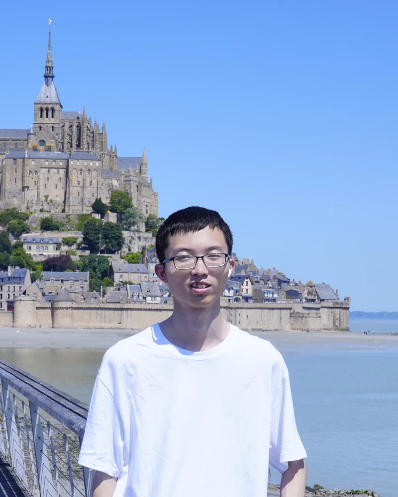 Weifei Jin standing outdoors at Mont Saint-Michel